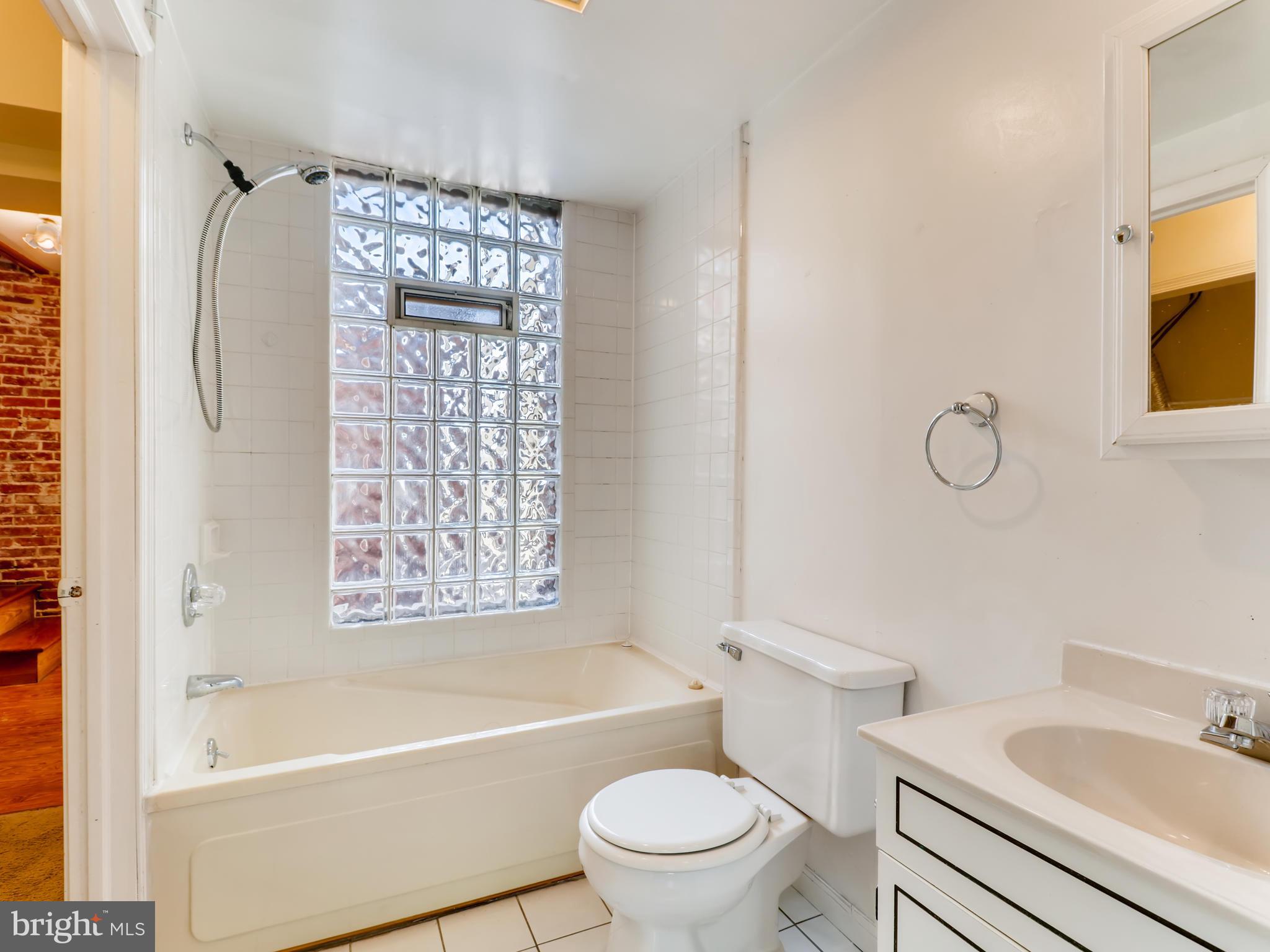 1434 Riverside Avenue Baltimore, MD 21230 - Photo 14 of 28 a bathroom with a toilet sink vanity tub and shower