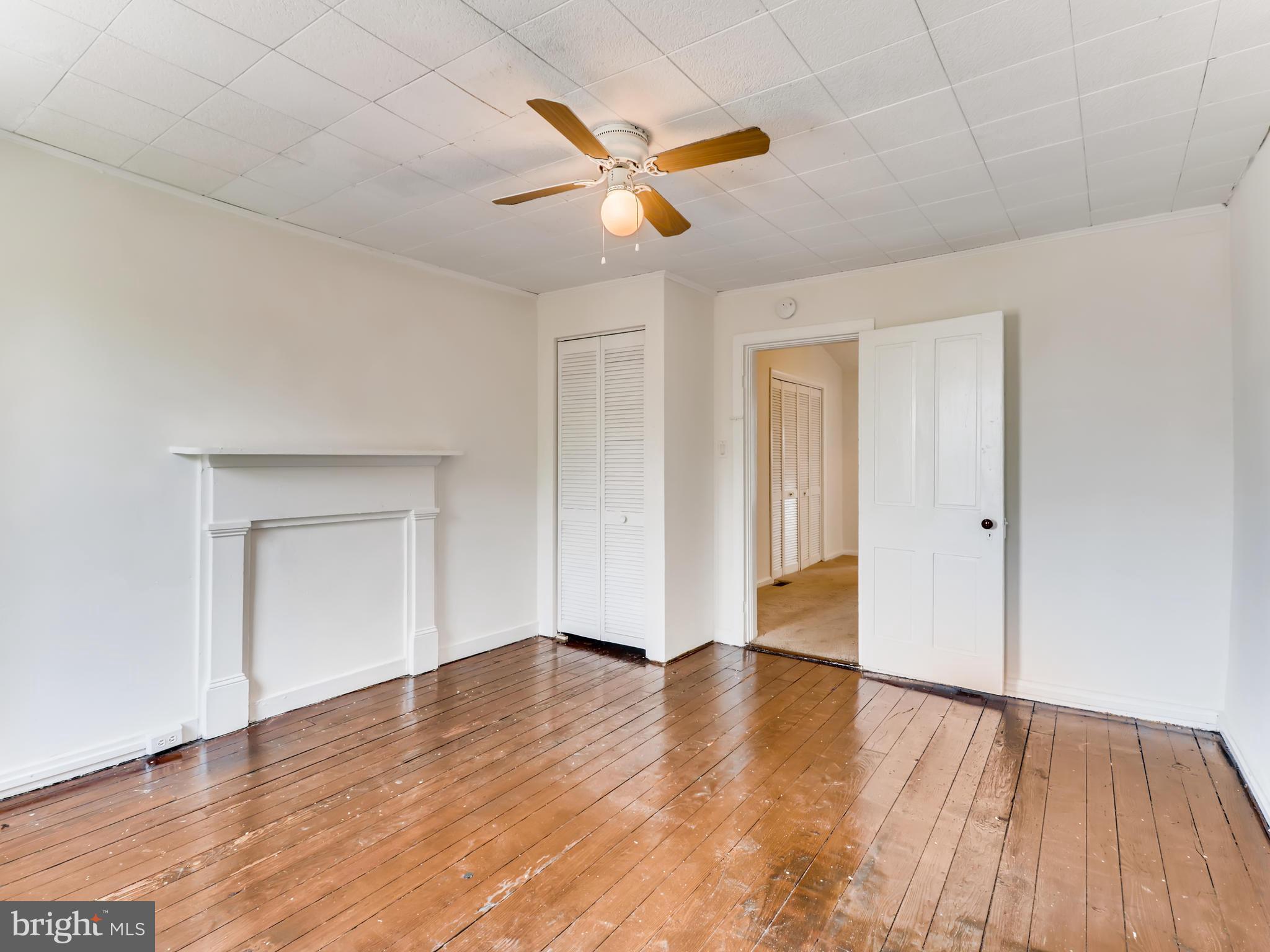 1434 Riverside Avenue Baltimore, MD 21230 - Photo 22 of 28 an empty room with wooden floor and a ceiling fan