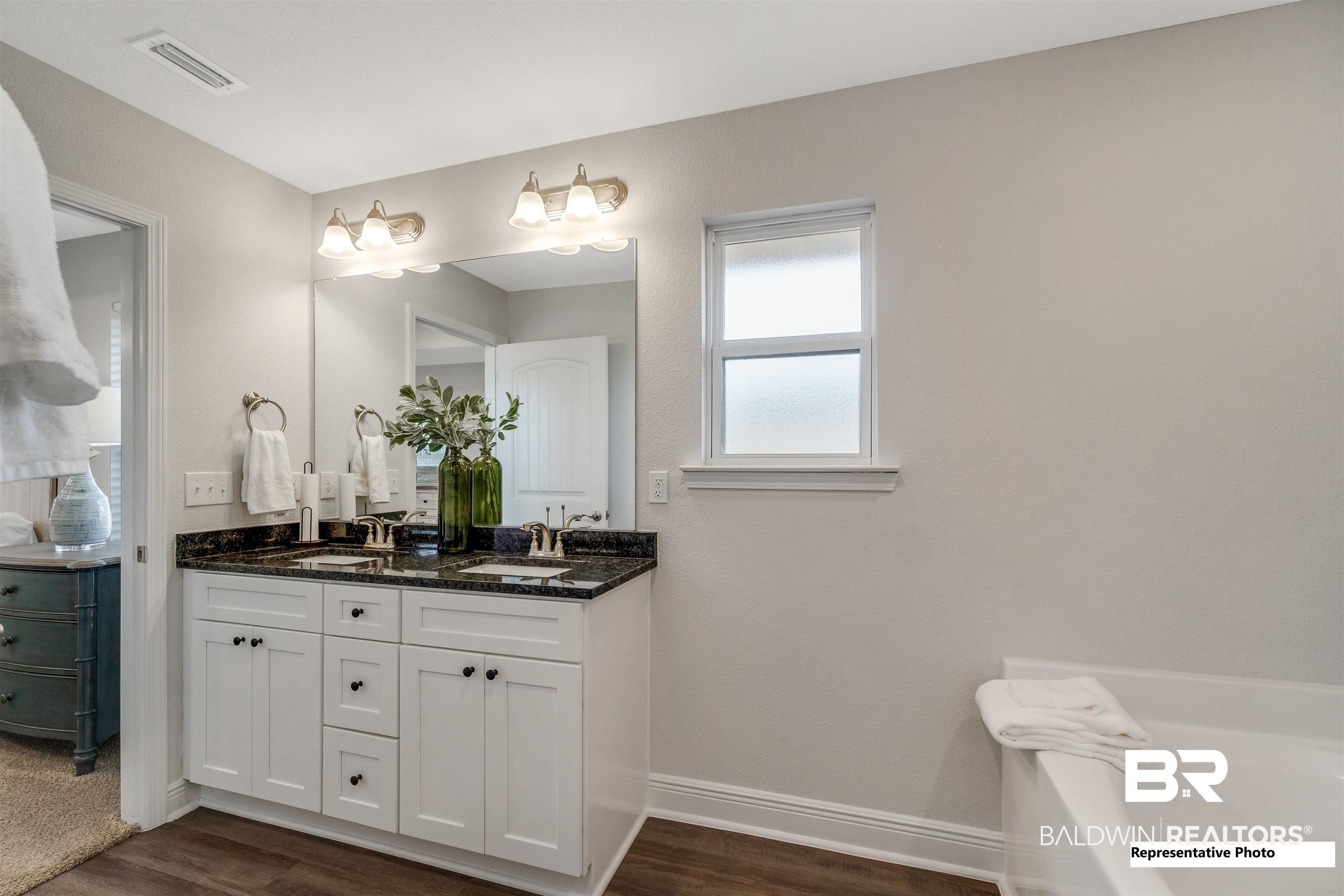 643 Mayflower Drive Foley, AL 36535 - Photo 26 of 34 Bathroom with double vanity, visible vents, a sink, and wood finished floors