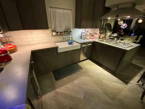 a kitchen with stainless steel appliances kitchen island granite countertop a refrigerator a stove and a sink with granite countertops