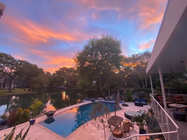 a view of a lake with couches chairs and swimming pool