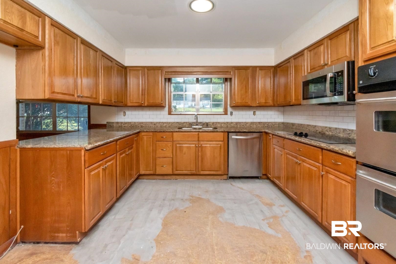 241 Suzanne Circle Mobile, AL 36608 - Photo 12 of 41 Kitchen featuring stainless steel appliances, brown cabinets, backsplash, stone counters, and recessed lighting