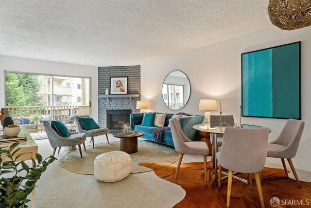 a living room with fireplace furniture and a large window