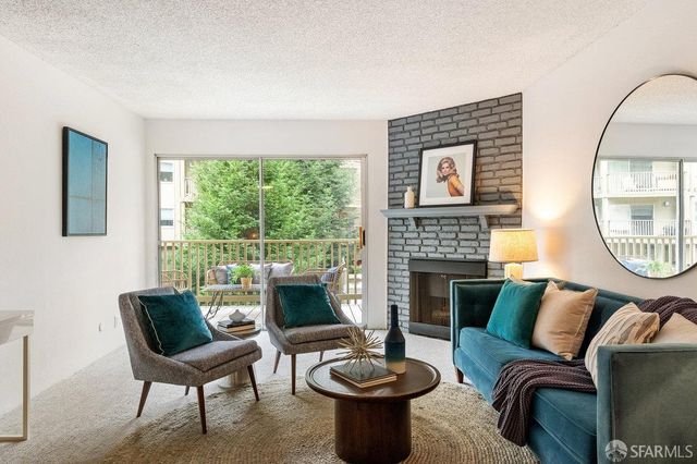 a living room with furniture a fireplace and a large window