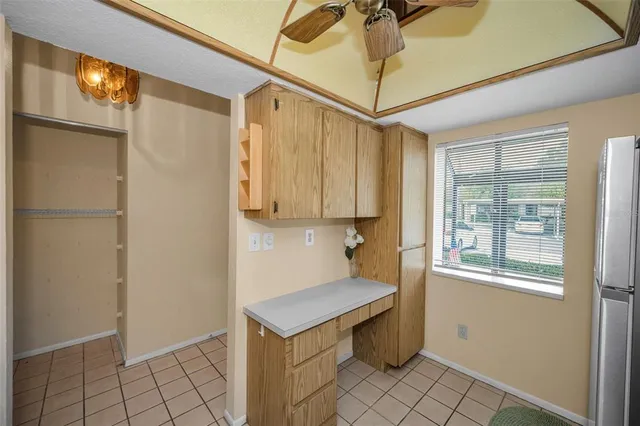 a view of a house with a swimming pool and a lawn chairs under a large tree
