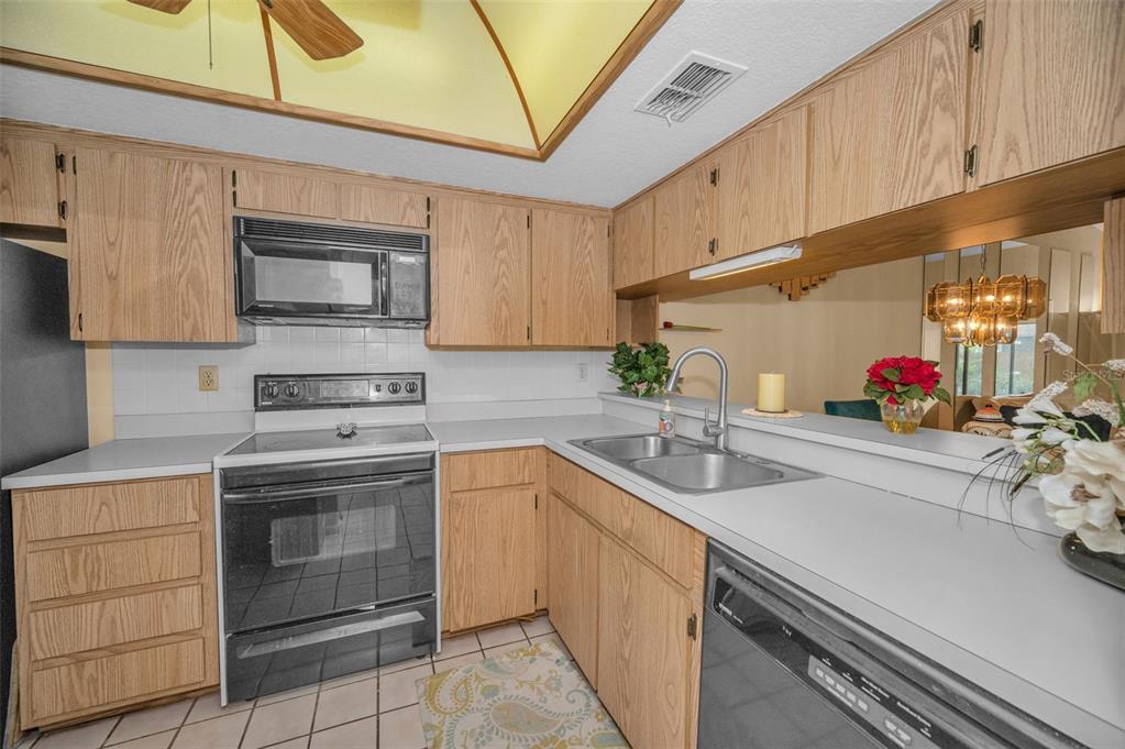 11511 113th Street, Unit 35E Largo, FL 33778 - Photo 22 of 77 a kitchen with stainless steel appliances granite countertop a sink stove and cabinets