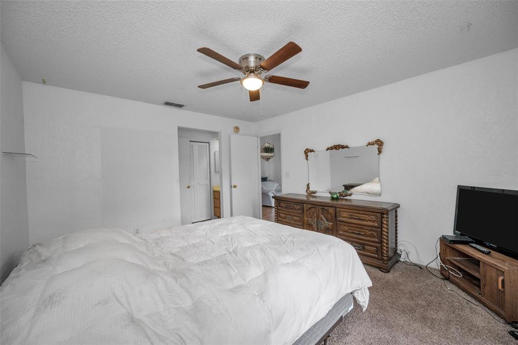 11511 113th Street, Unit 35E Largo, FL 33778 - Photo 23 of 77 a bedroom with a bed and a flat screen tv