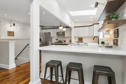 a kitchen with cabinets and chairs