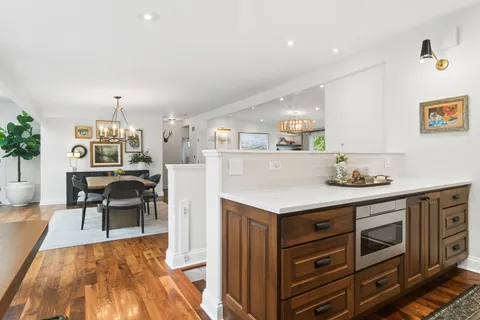a kitchen with granite countertop a stove cabinets and dining table