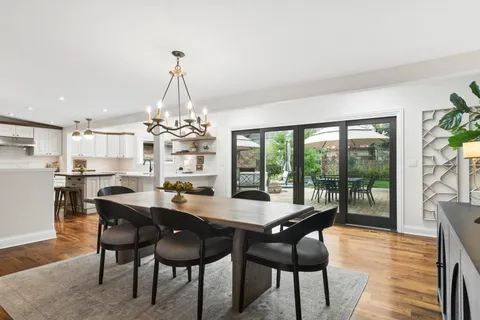 a dining room with furniture a chandelier and wooden floor