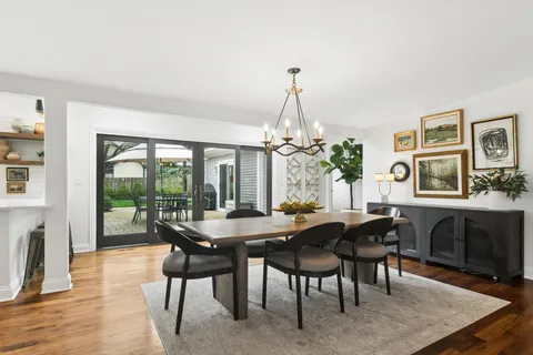 a dining room with furniture a chandelier and wooden floor