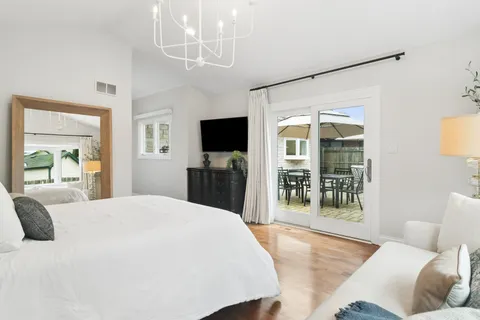 a spacious bedroom with a large bed and a flat tv screen on dresser