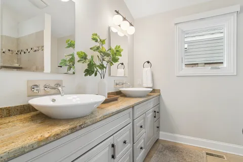 a bathroom with a granite countertop sink and a mirror