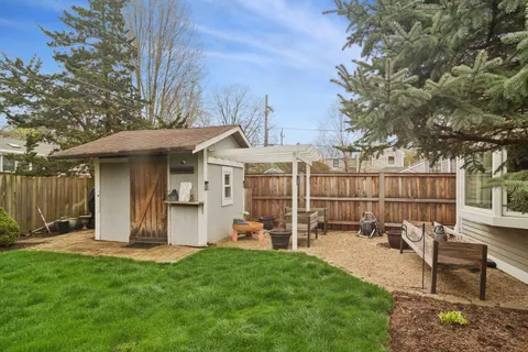 a view of a chair and table in backyard of the house