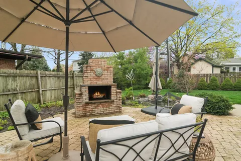 a view of a patio with a table and chairs under an umbrella