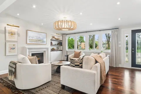 a living room with furniture a fireplace and a large window