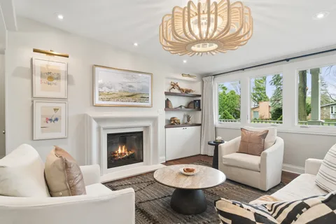 a living room with furniture a fireplace and a large window