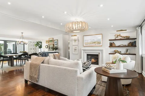 a living room with furniture a fireplace and a chandelier