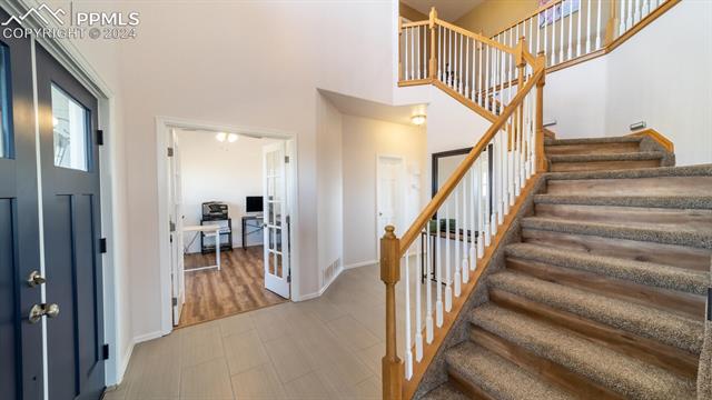 11125 Eureka Road Calhan, CO 80808 - Photo 8 of 44 Staircase featuring tile flooring and a towering ceiling