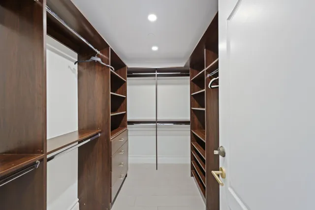 a view of walk in closet with clothes and shoes