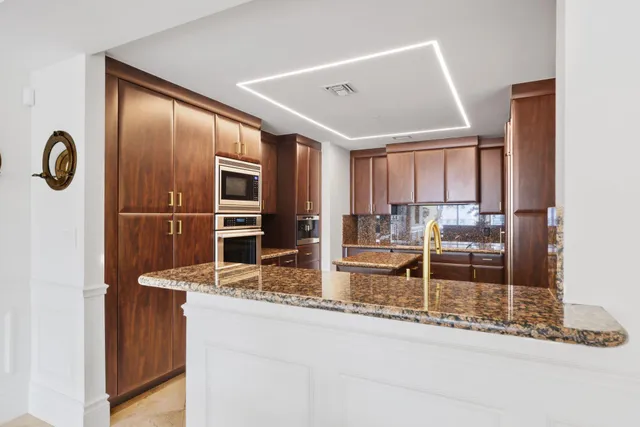 a kitchen with kitchen island granite countertop cabinets and refrigerator