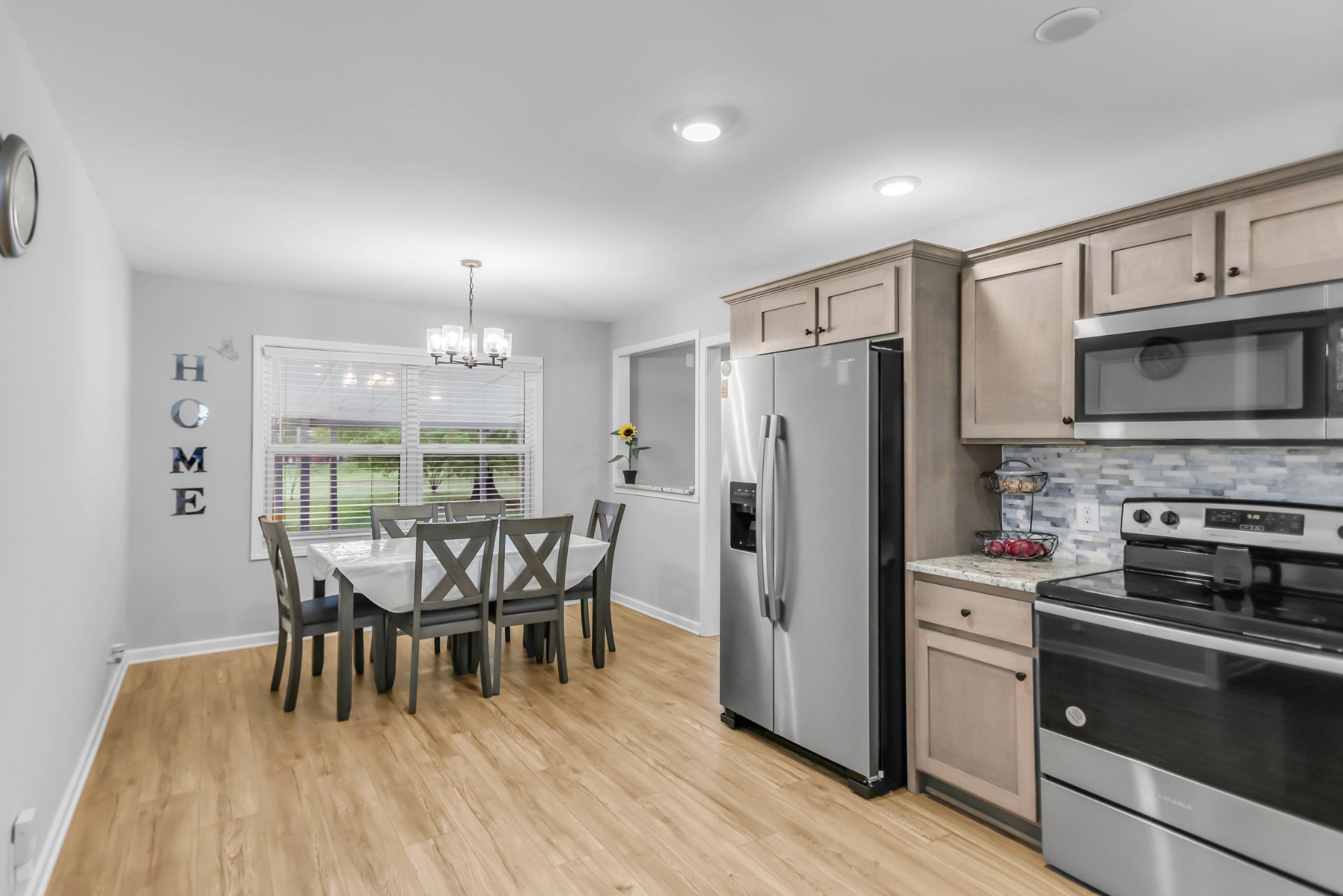 105 Jerry Street Portland, TN 37148 - Photo 7 of 40 a kitchen with stainless steel appliances a dining table chairs refrigerator and cabinets