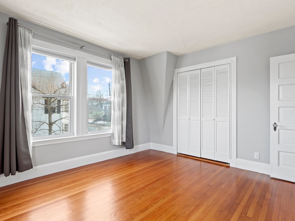 169 George Street Medford, MA 02155 - Photo 12 of 22 a view of an empty room with wooden floor and a window