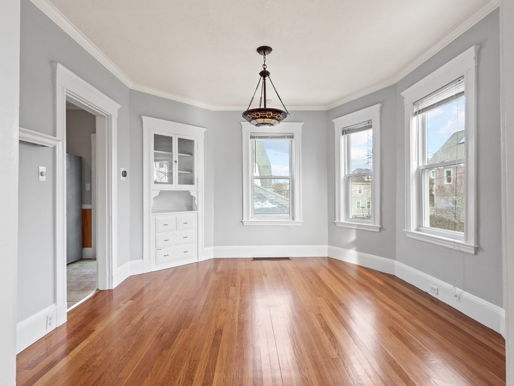 169 George Street Medford, MA 02155 - Photo 2 of 22 a view of an empty room with wooden floor and a window