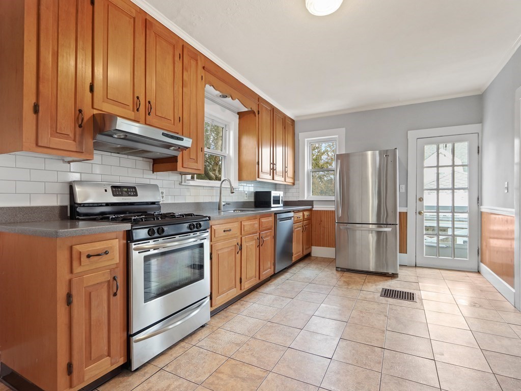 169 George Street Medford, MA 02155 - Photo 5 of 22 a kitchen with stainless steel appliances granite countertop a stove a sink dishwasher a refrigerator and cabinets with wooden floor