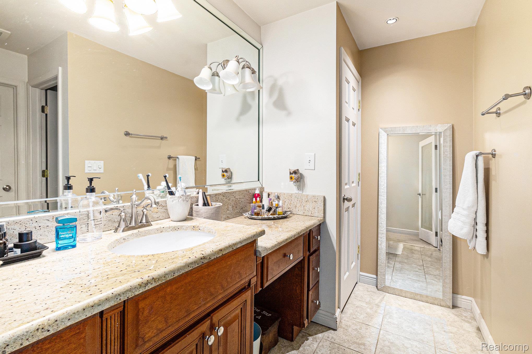 14017 North Belsay Road Millington, MI 48746 - Photo 14 of 43 Bathroom featuring vanity, light tile patterned floors, and a chandelier