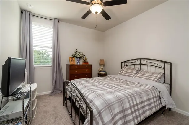 a bedroom with a bed and a flat tv screen on the dresser