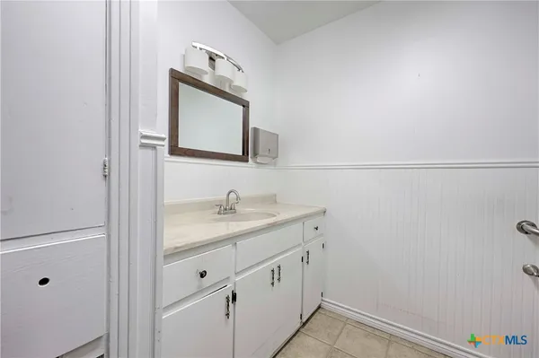 a bathroom with a granite countertop sink vanity and mirror