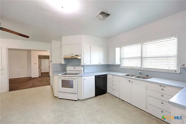 a kitchen with granite countertop white cabinets and white appliances