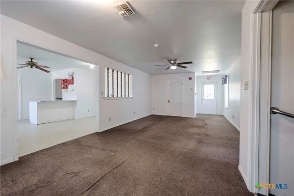 an empty room with staircase and white walls
