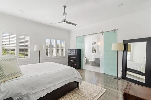 a spacious bedroom with a bed and wooden floor