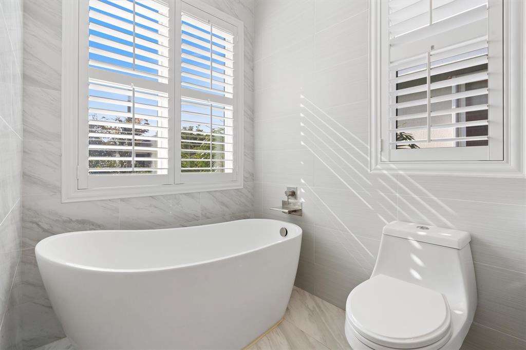 518 Southwest 9th Street, Unit 518 Fort Lauderdale, FL 33315 - Photo 22 of 29 a white bath tub sitting next to a toilet