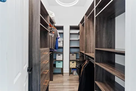 a view of walk in closet with clothes and shoes