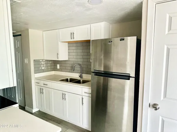 a kitchen with a refrigerator a sink and cabinets
