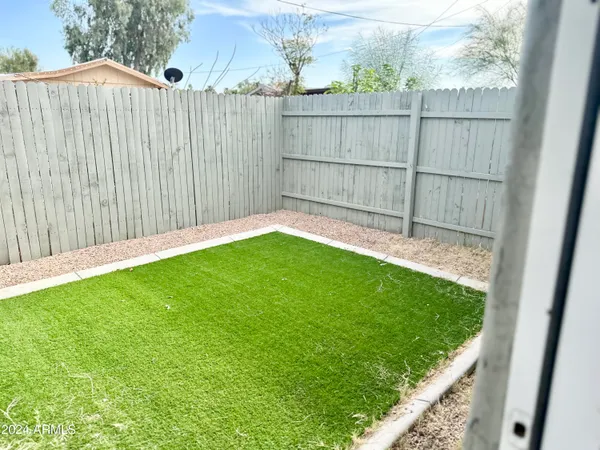 a view of a backyard with a wooden fence