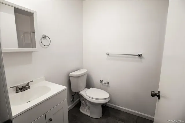 a bathroom with a toilet a sink and mirror