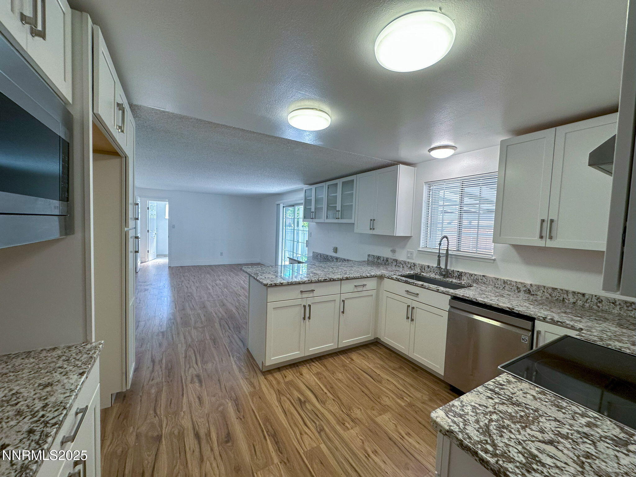 3095 Randolph Drive Reno, NV 89502 - Photo 3 of 20 a kitchen with granite countertop cabinets stainless steel appliances a sink and a wooden floor
