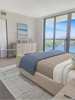 a bedroom with a large bed and a flat tv screen