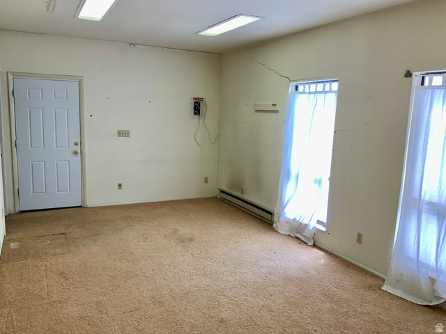 630 North Main Street Monroe, UT 84754 - Photo 45 of 63 Empty room in shop with light carpet and a baseboard radiator