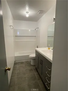 an empty room with wooden floor ceiling fan and windows