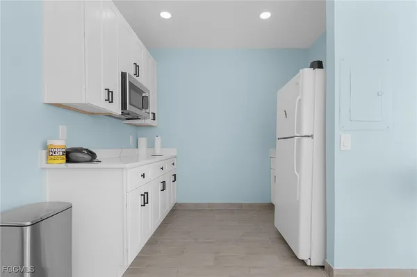 a kitchen with cabinets and wooden floor