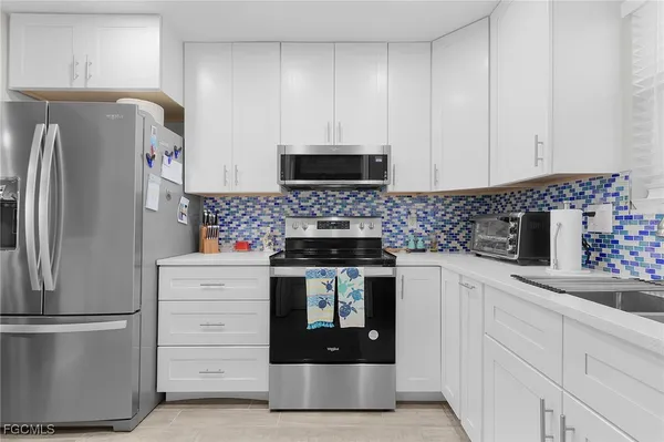 a kitchen with appliances a sink and cabinets