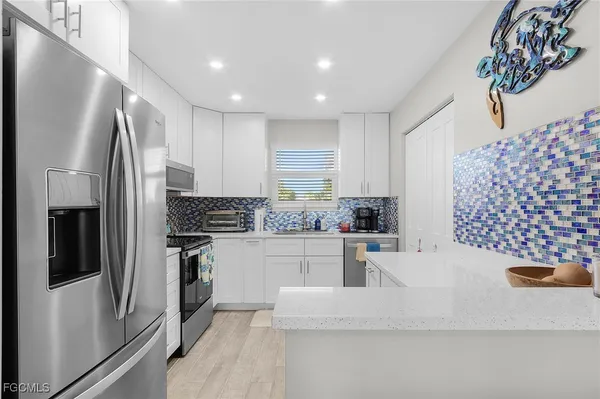 a kitchen with stainless steel appliances kitchen island granite countertop a refrigerator and a stove top oven