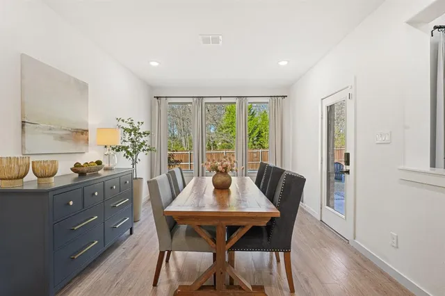 a dining room with furniture window and wooden floor
