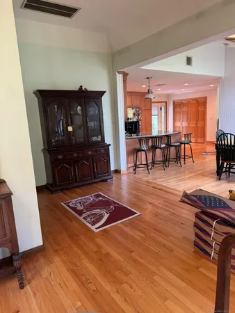 a living room with furniture a dining table and chairs with wooden floor