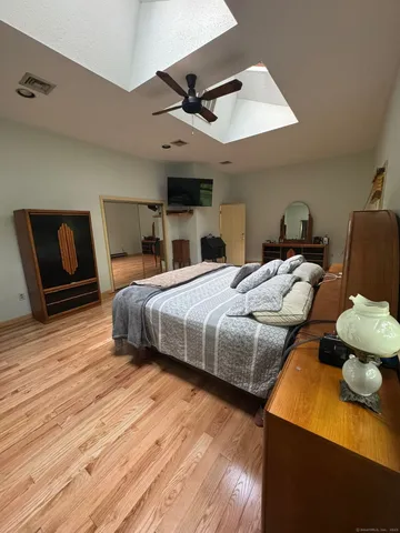 a bedroom with bed and wooden floor